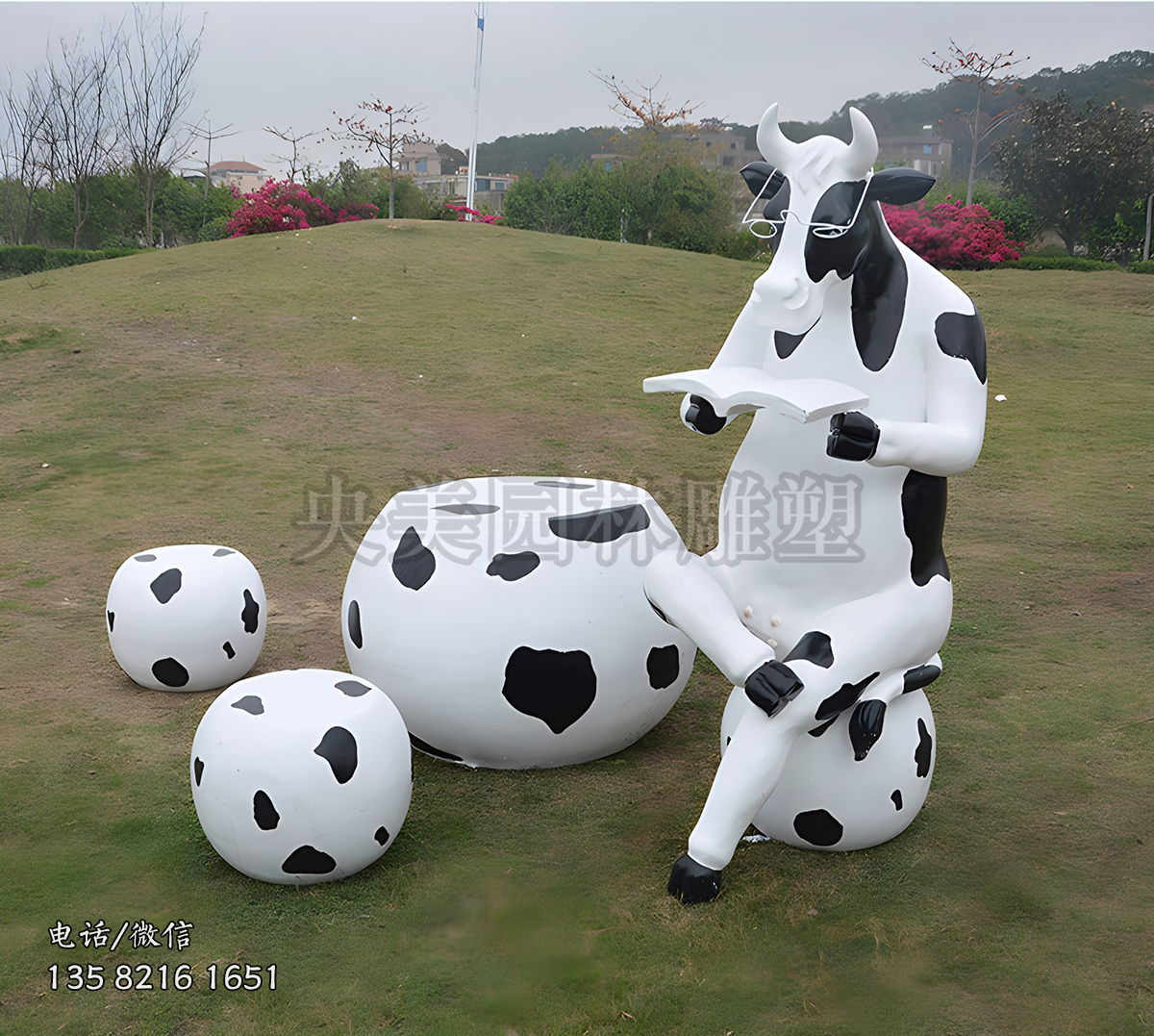 坐在圓凳上看書的卡通奶牛雕塑