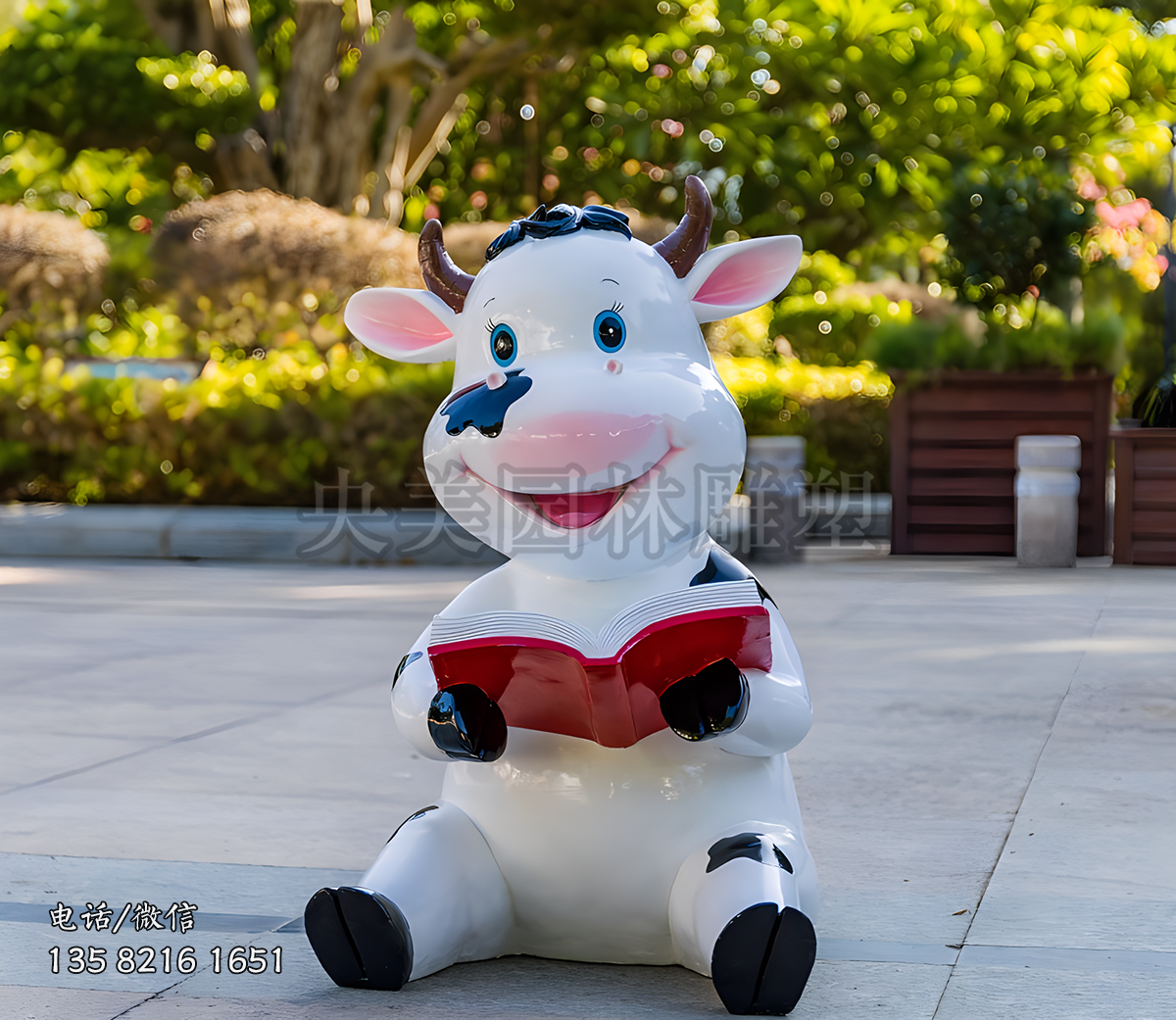 坐地上看書的卡通小奶牛雕塑
